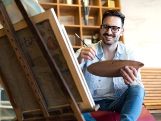 Man achter schildersezel maakt een schilderij