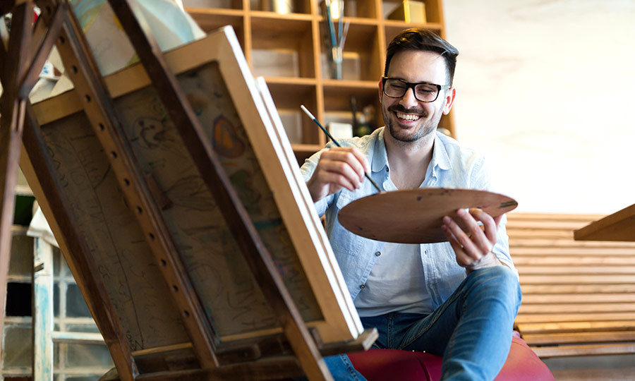 Man achter schildersezel maakt een schilderij