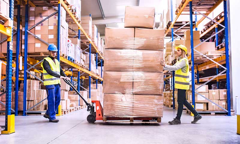 Operators in een magazijn verplaatsen een palletwagen